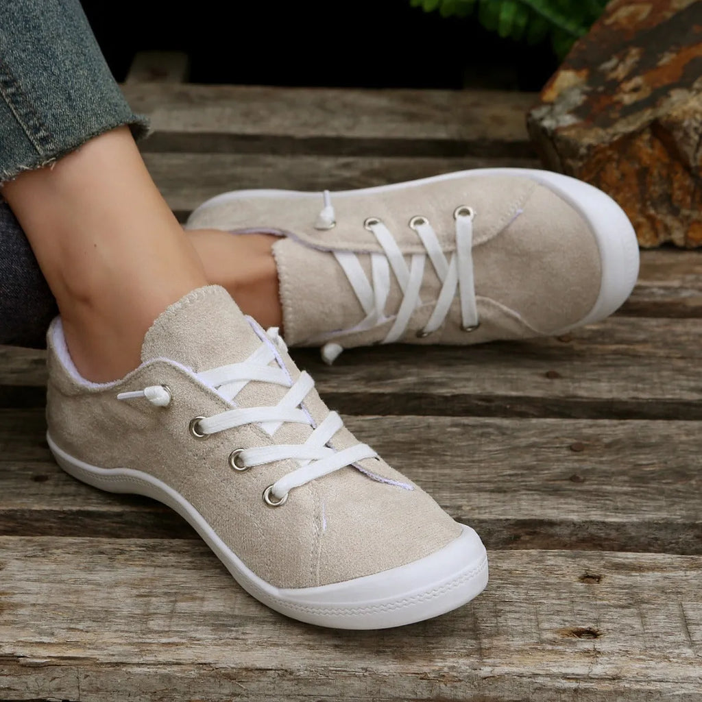 Women's creamy white fabric casual sneakers with rubber soles showing low-top design