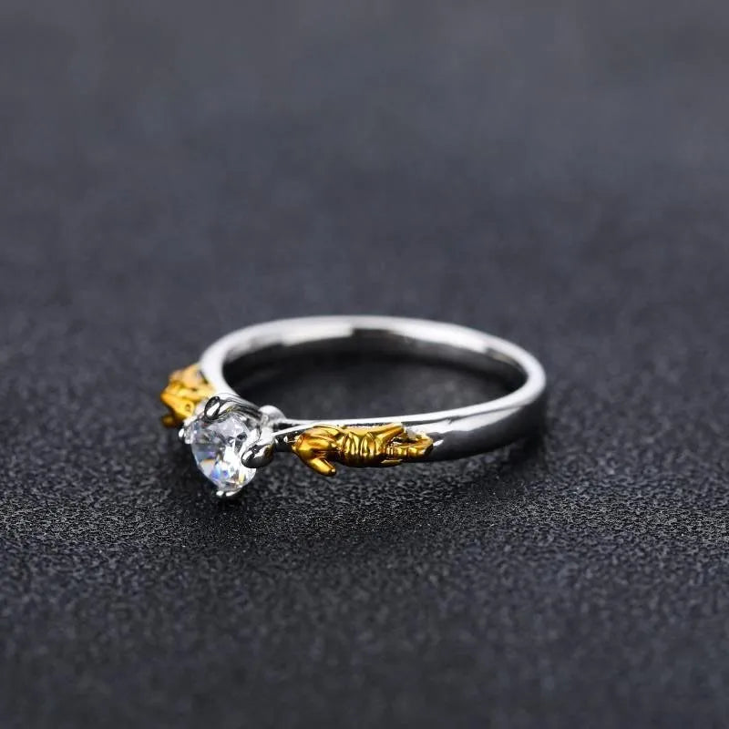 Copper crown ring with crystals in a black gold finish, shown on a finger.