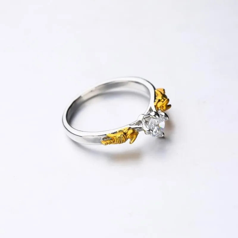Copper crown ring with crystals in a black gold finish, shown on a finger.