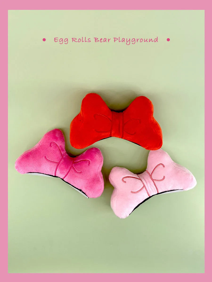 Plush fabric bow decoration for motorcycle and ski helmets in red, peach pink, or rose pink.