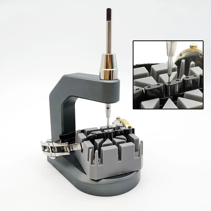 Silver multi-purpose press strap removal tool made from tool steel on a work surface.
