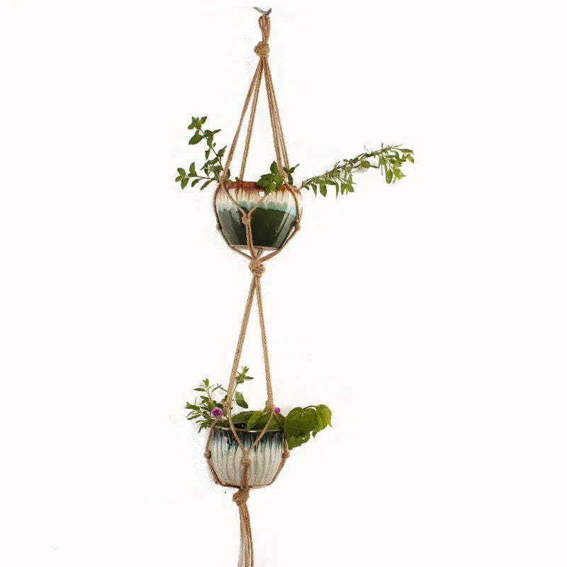 Woven cotton rope plant hanger in a hanging configuration holding a potted plant.