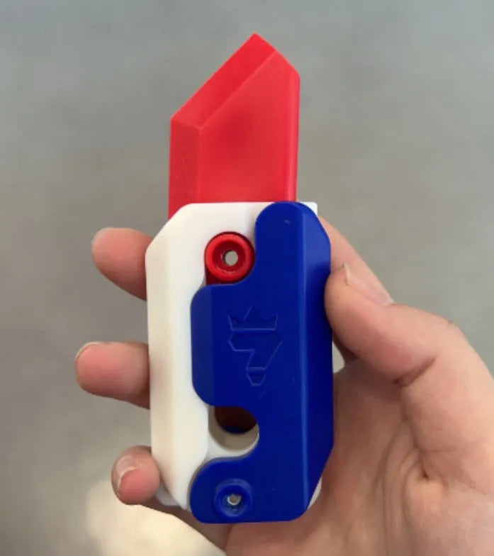 3D printed gravity carrot fidget knife in orange, purple and green colour on white background