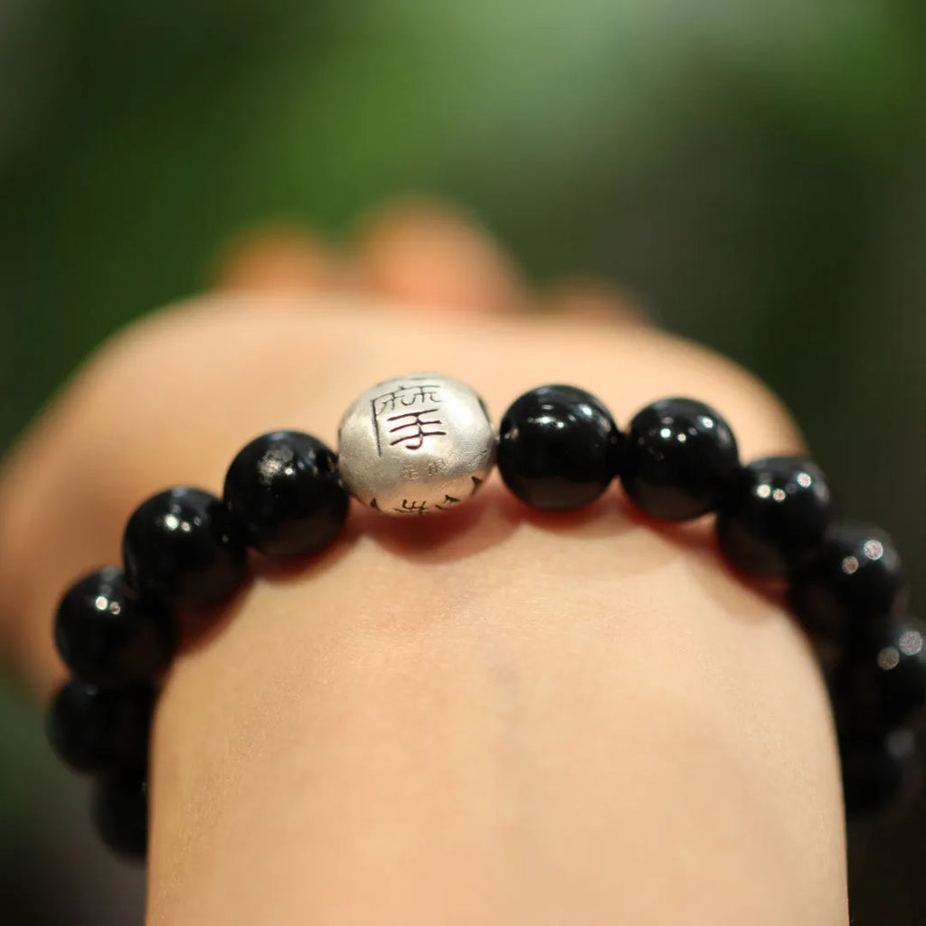 Close-up of a women's bracelet with large 10mm black agate beads on a shiny silver alloy chain in a Chinese style.