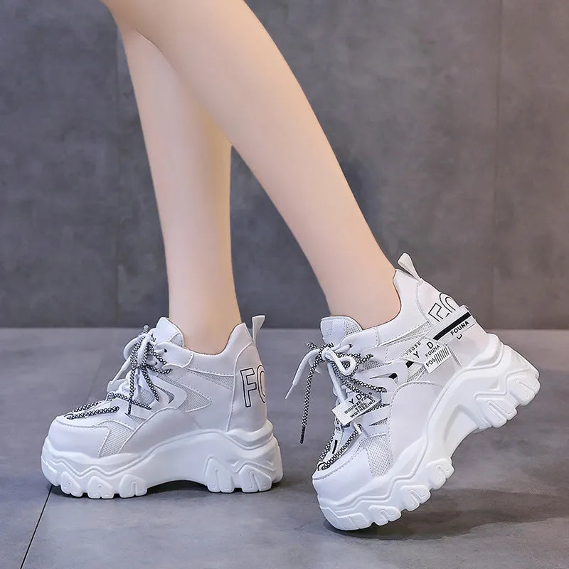 Women's white mesh platform trainers with cross strap and rubber sole showing side profile