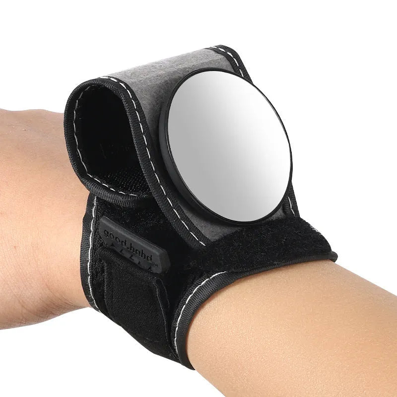 Black nylon wrist-mounted bicycle rear-view mirror shown on a cyclist's wrist.