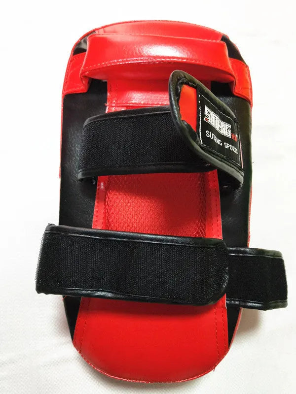 Black and red square hand-held martial arts foot target pad with buckle straps.