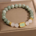 Women's oil green emerald crystal bracelet with five scripture pieces on a wrist.