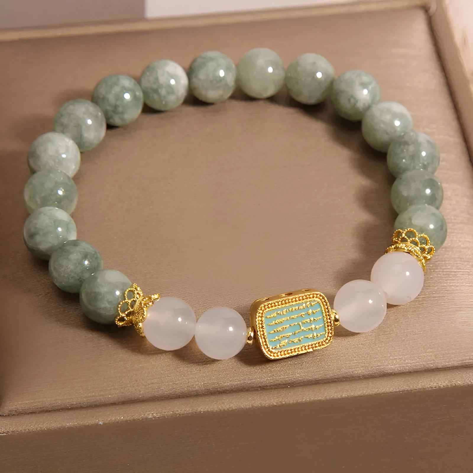Women's oil green emerald crystal bracelet with five scripture pieces on a wrist.