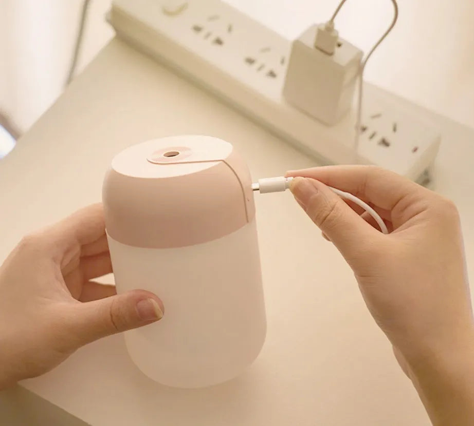 Small white cylindrical USB-powered humidifier with aromatherapy function on a desk