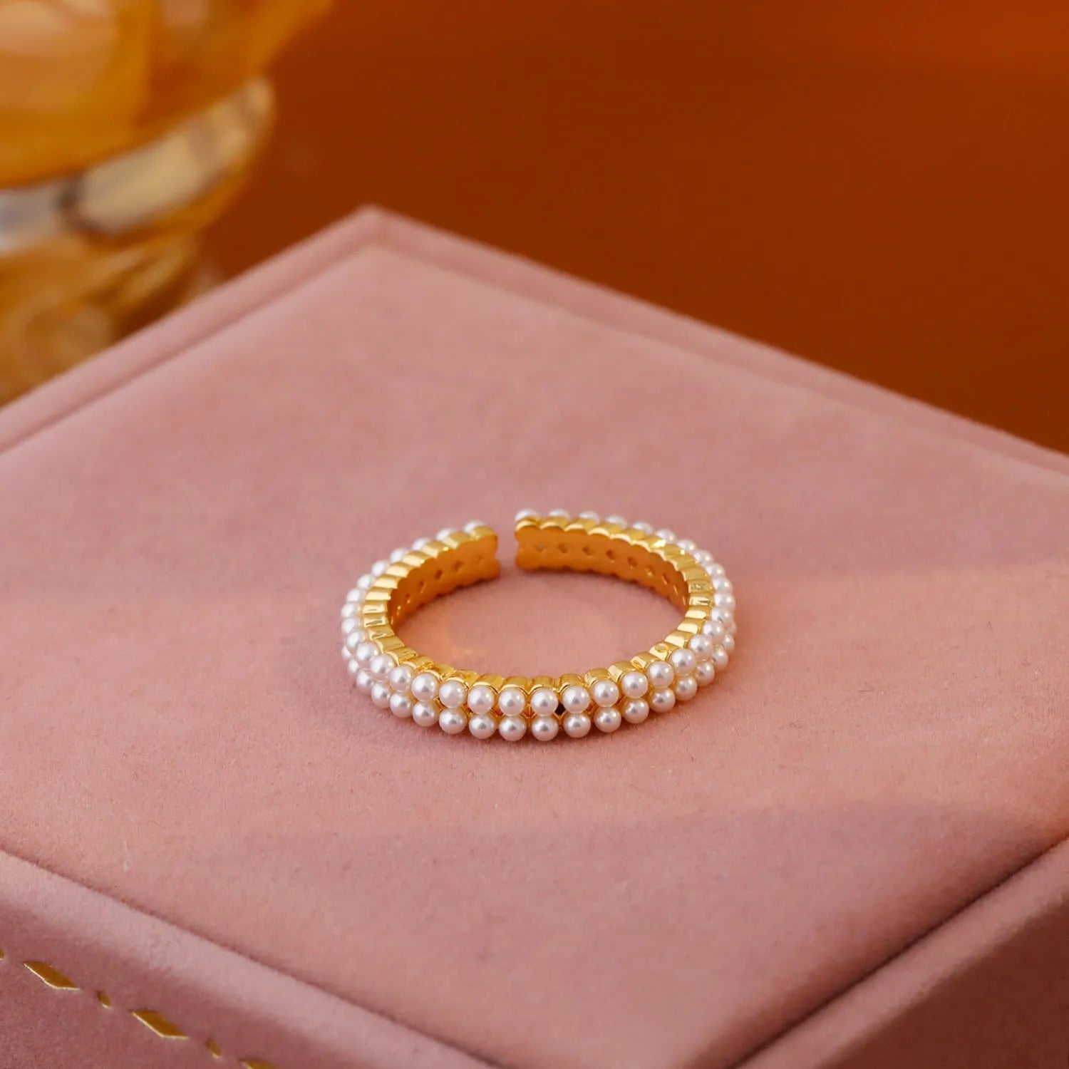 Gold geometric open mouth ring with pearl detail on female hand