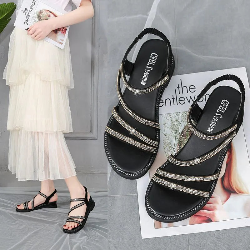 Women's gold casual flat sandals with rhinestone detail and elastic band on a rubber sole.