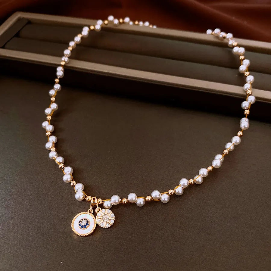 Gold electroplated round pendant necklace with zircon pearl on an adjustable clavicle chain.