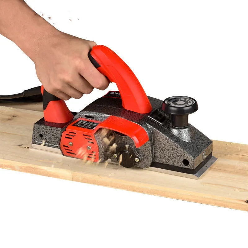 Red desktop electric wood planer with aluminium body showing 82mm planing width and power cord