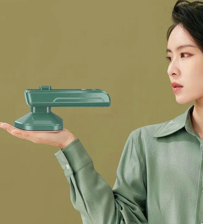 Dark green portable handheld hanging steam ironing machine with ceramic panel on a white background.
