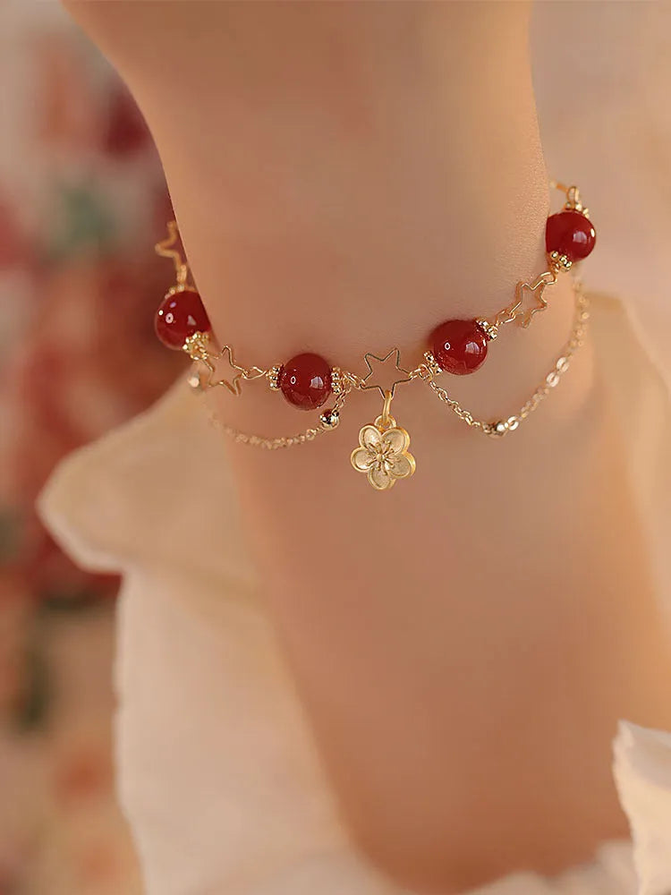 Red agate double layer bracelet with floral and peach blossom charms on adjustable band