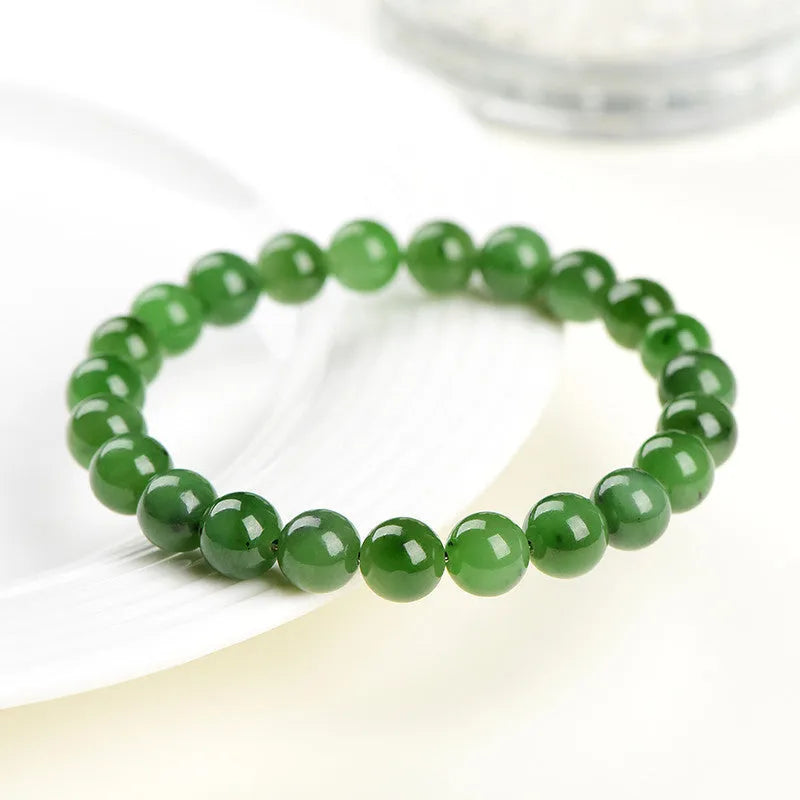 Natural Hetian jade and jasper bead bracelet showing polished spherical beads on a wrist.
