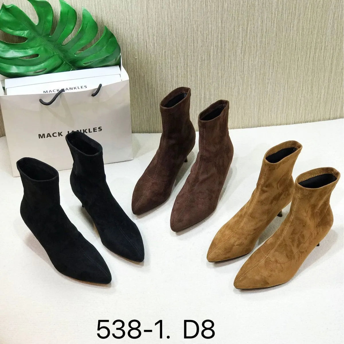 Women's black pointed toe ankle boots with a stiletto heel on a plain background