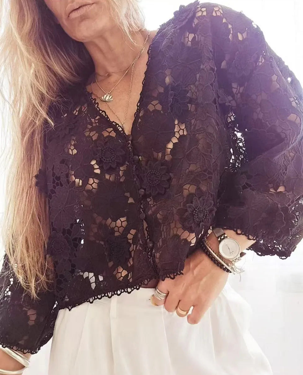 Loose V-neck lace cardigan with white three-dimensional floral decorations on a black background.