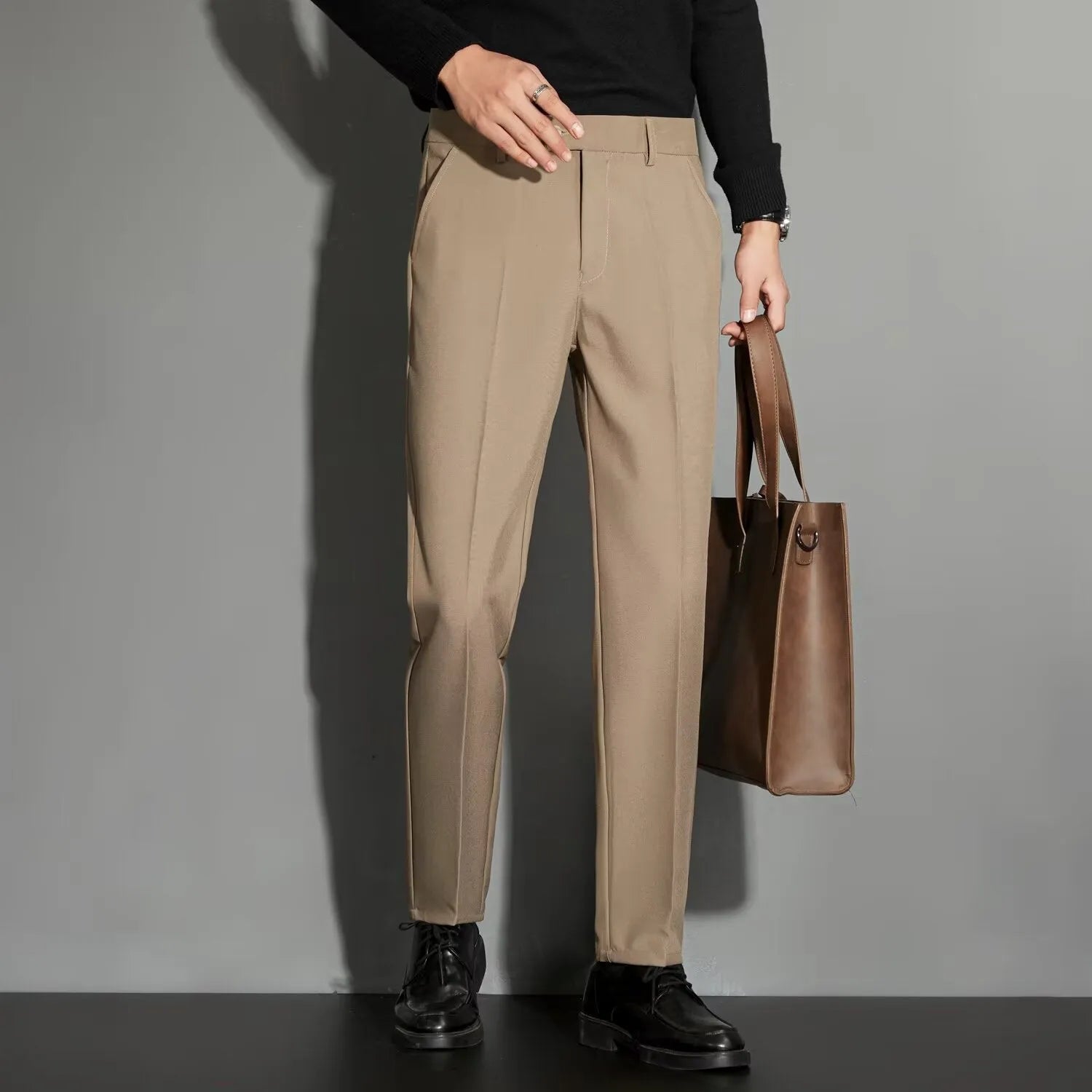 Men's straight-fit ankle-length suit trousers in a light gray colour, showing the draping effect.