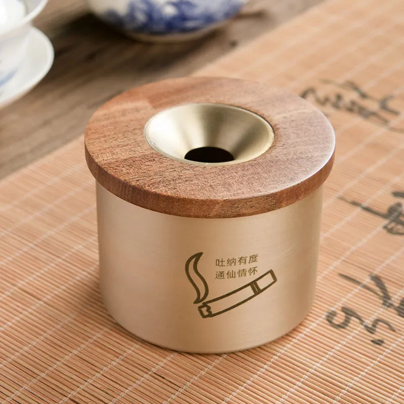 Brass ashtray with wooden lid showing central aperture design