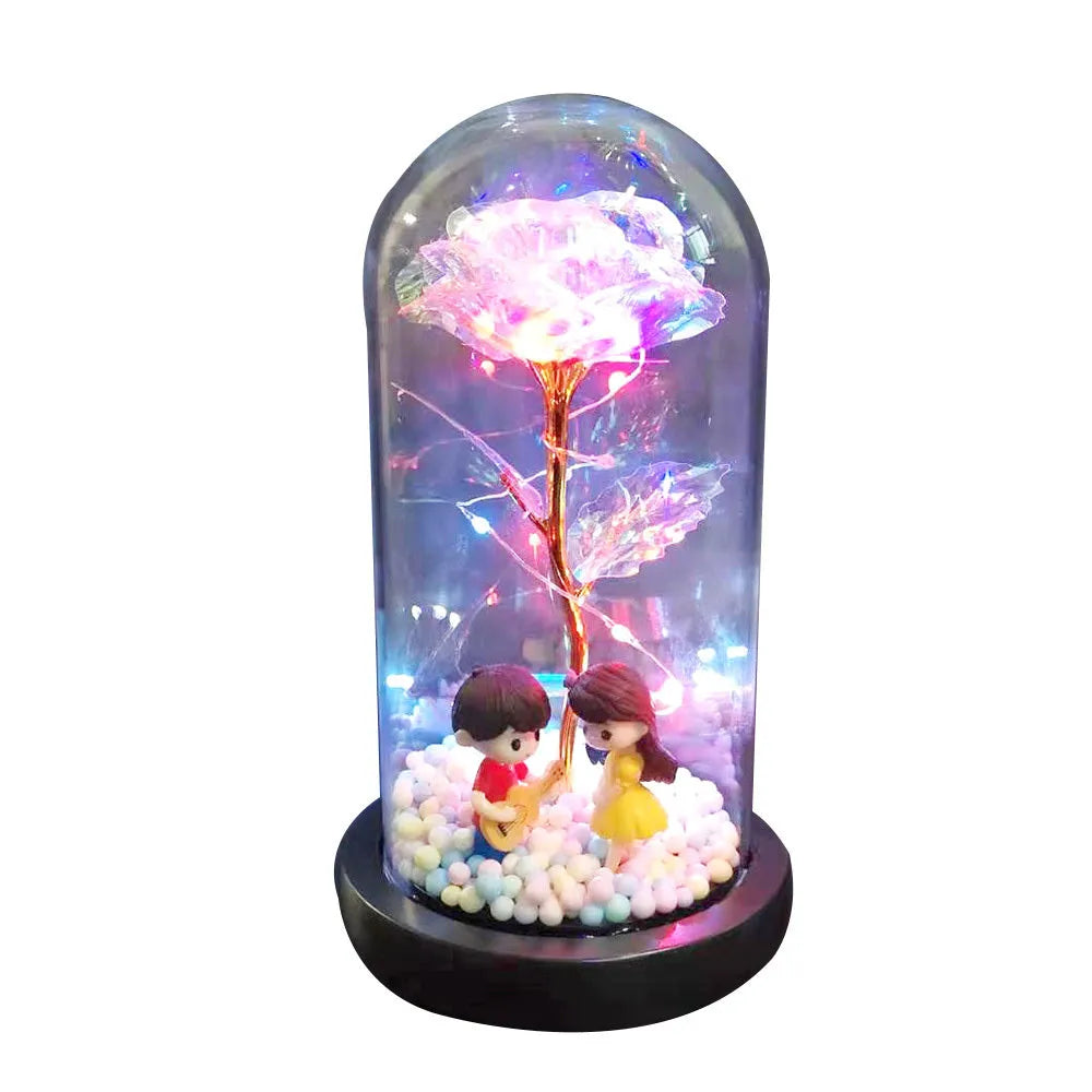 Artificial gold rose in glass flask with LED lights on black base, 20cm tall