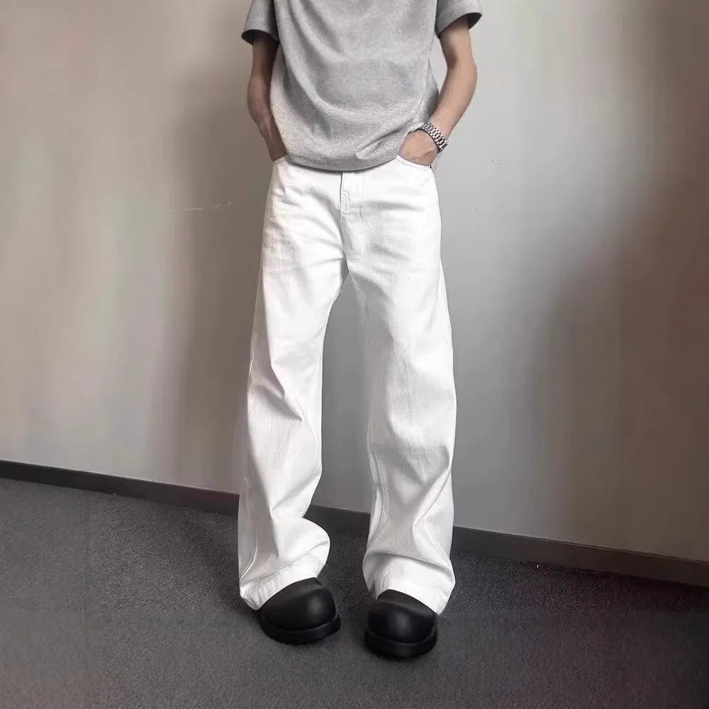 Men's loose fit straight leg white denim jeans on a hanger, showing wide leg opening and zipper fly.