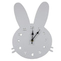 Wooden cartoon wall clock with playful design, such as a rabbit or alien, showing colour options and battery compartment.