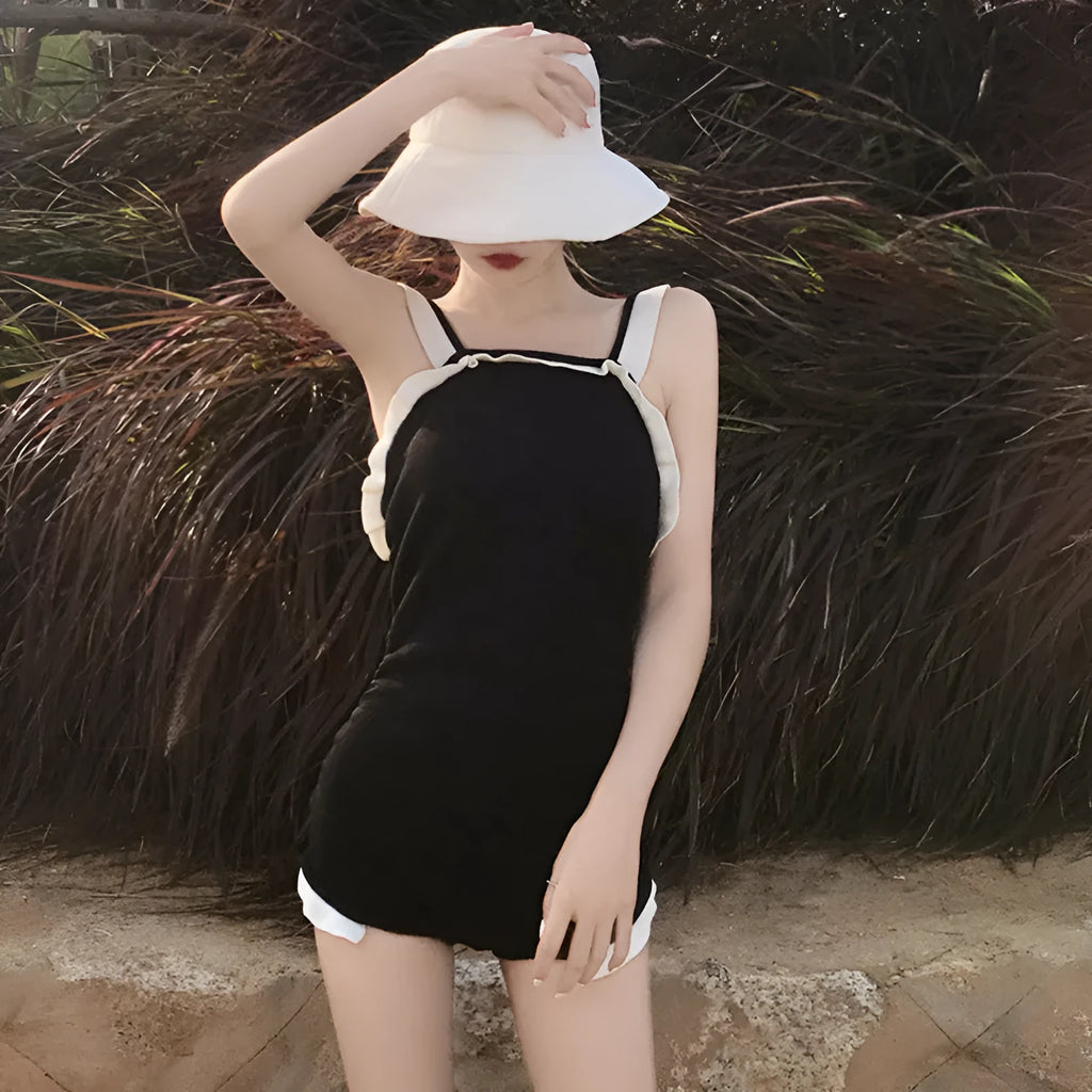 Conservative one-piece swimsuit for women in black with white edge, nylon fabric, size S to XL