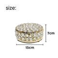 Clear crystal glass jewellery box with a French gold metal frame on a table.