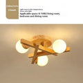 Nordic style wooden ceiling lamp with three light heads emitting neutral colour illumination