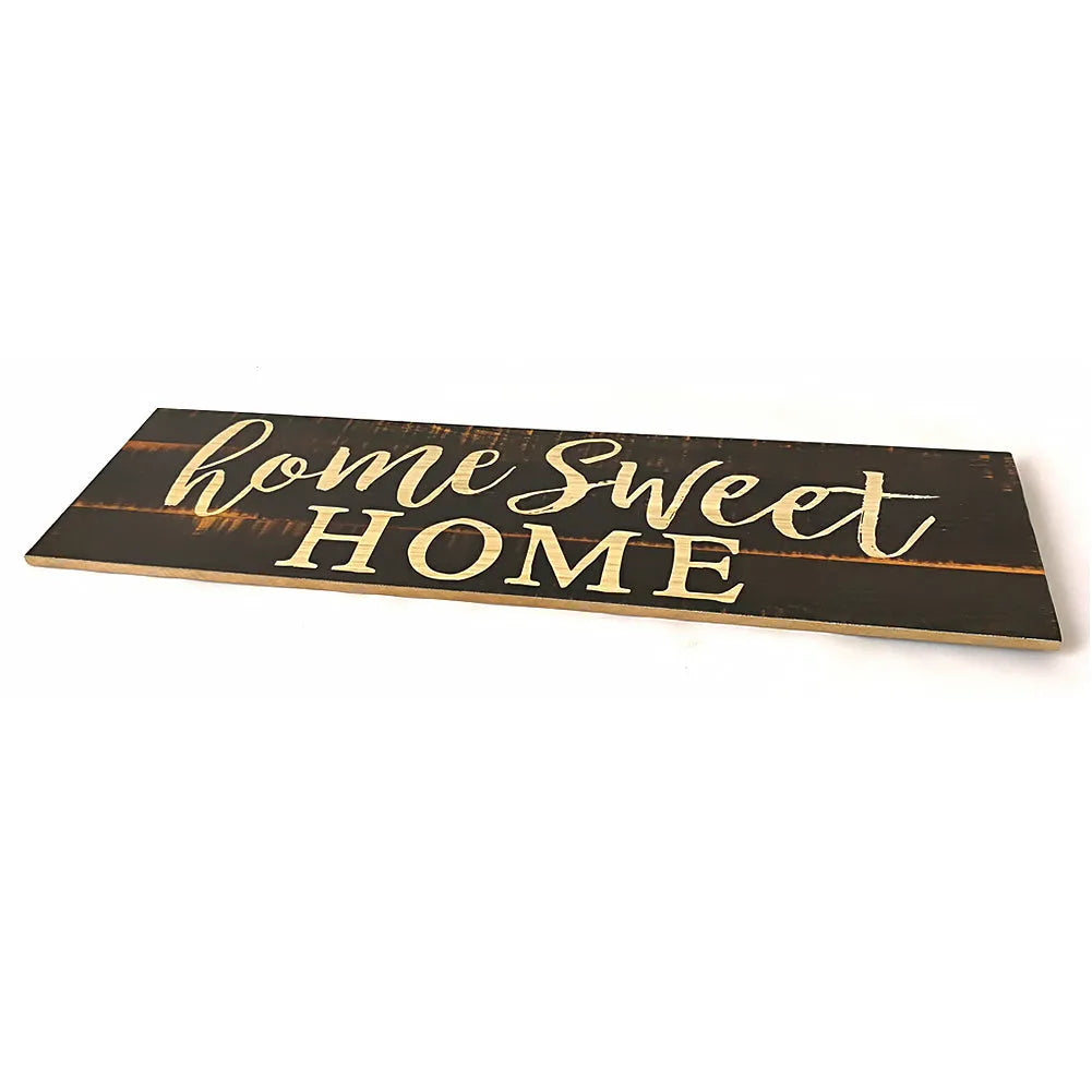 Wooden carved Home Sweet Home hanging pendant decoration in black finish on a light wall