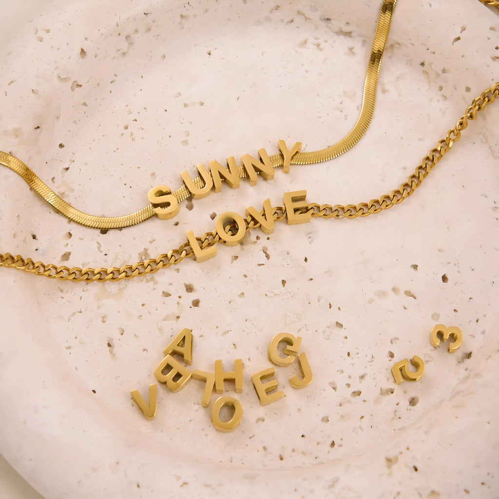 Gold and silver titanium steel necklaces with letter, number, and heart pendants on 40cm chains.