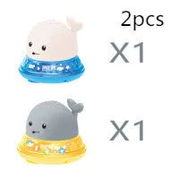 White and blue electric whale bath toy spraying water with lights on a base.