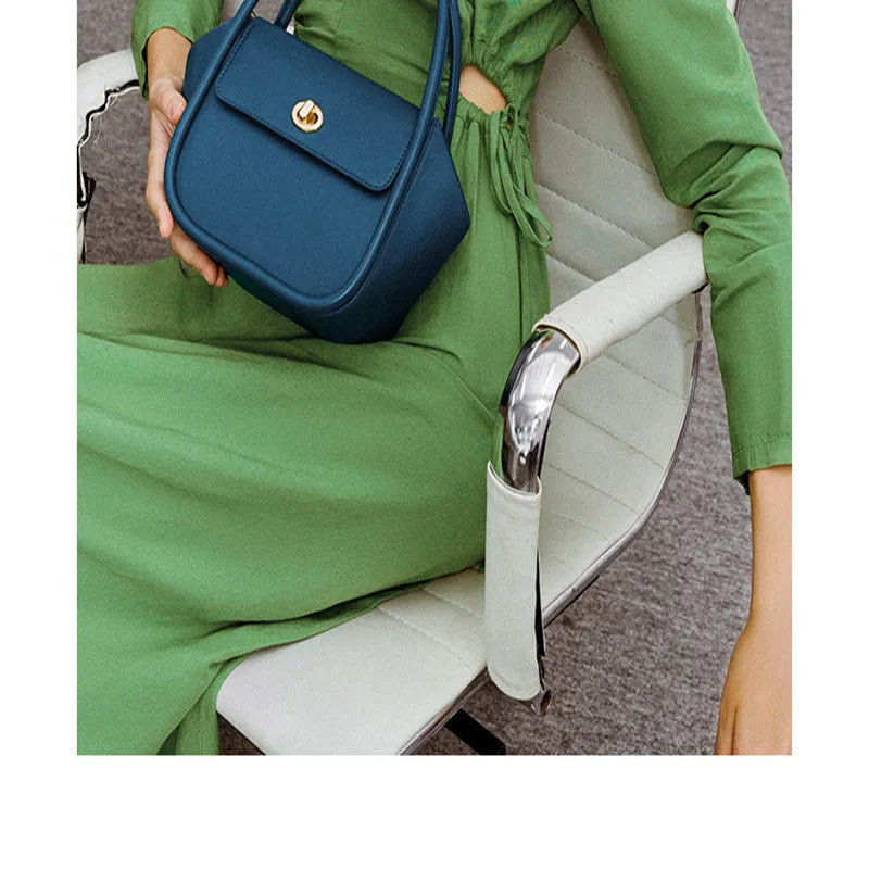Soft wing-shaped leather cross-body tote bag in cow leather with a buckle and latch closure.