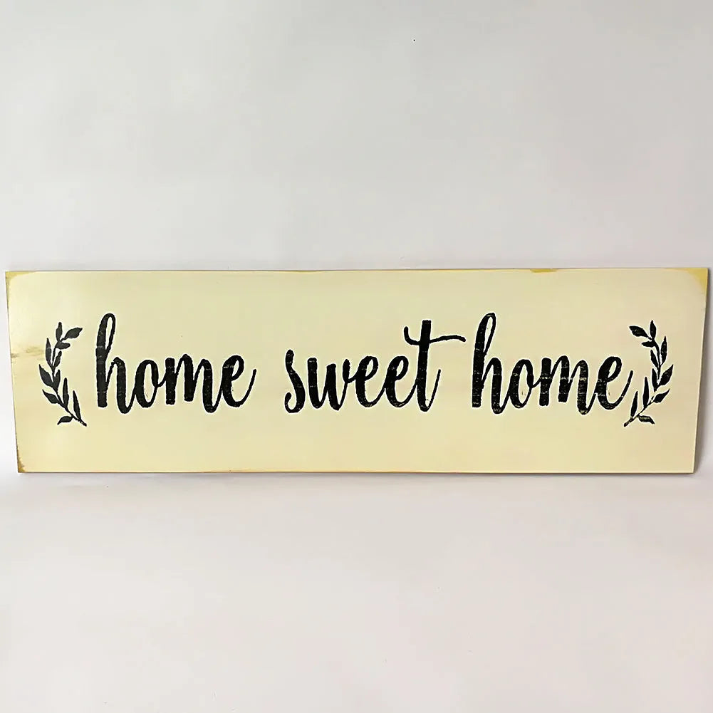 Wooden carved Home Sweet Home hanging pendant decoration in black finish on a light wall