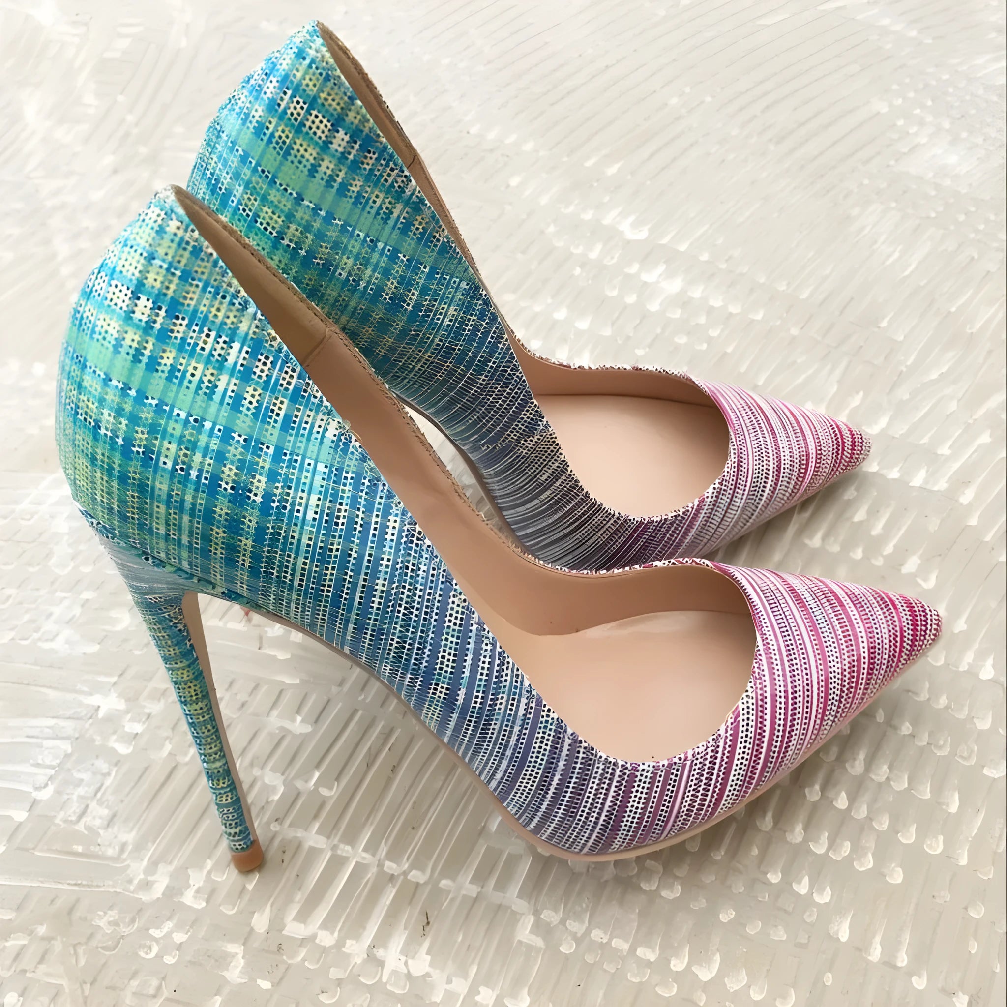 Ladies pointed-toe high heels in a pink to blue gradient patent leather with a rubber sole.