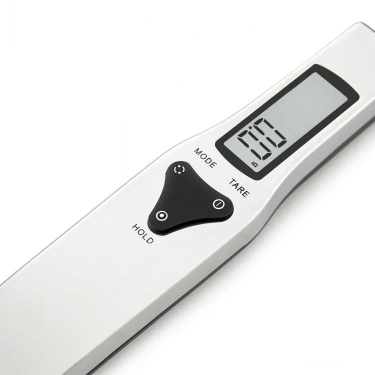 Digital smart measuring spoon with LCD display showing weight reading, on a kitchen countertop