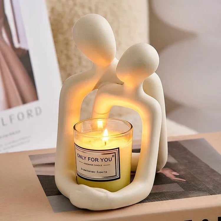 Modern milky white resin statue of an embracing couple, 12cm tall, on a wooden desk.