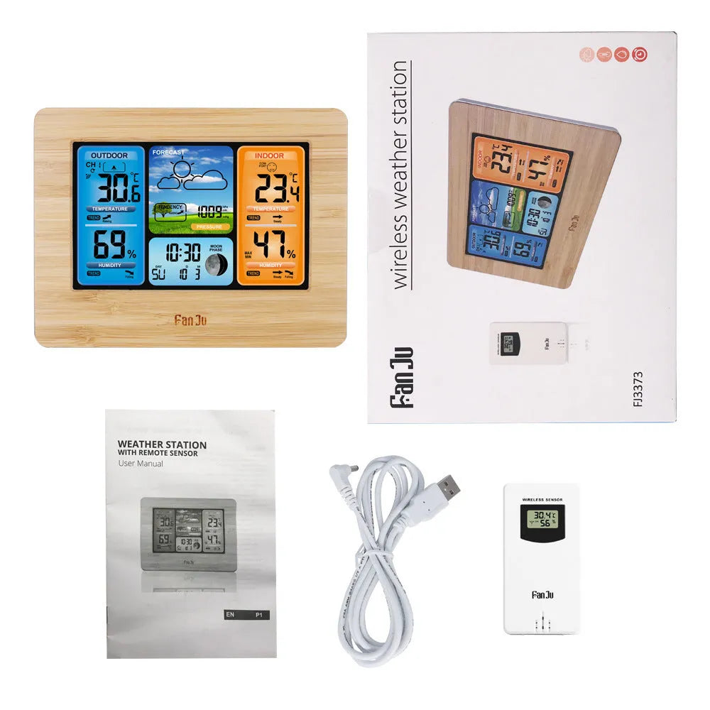 Rectangular black digital weather station with LCD display showing time, temperature, and weather icons on a desk.