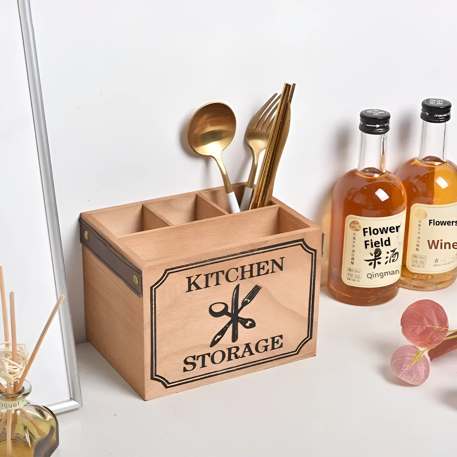 Open wooden kitchen storage box with internal grid holding knives, forks, and chopsticks.