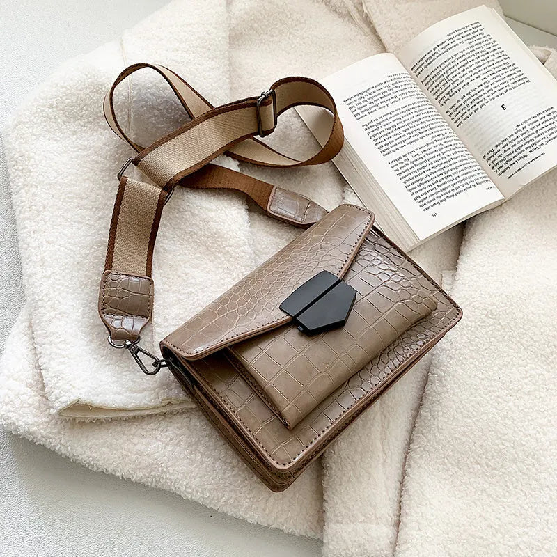 Vintage-style women's crossbody bag in PU leather, shown in black, with adjustable strap.