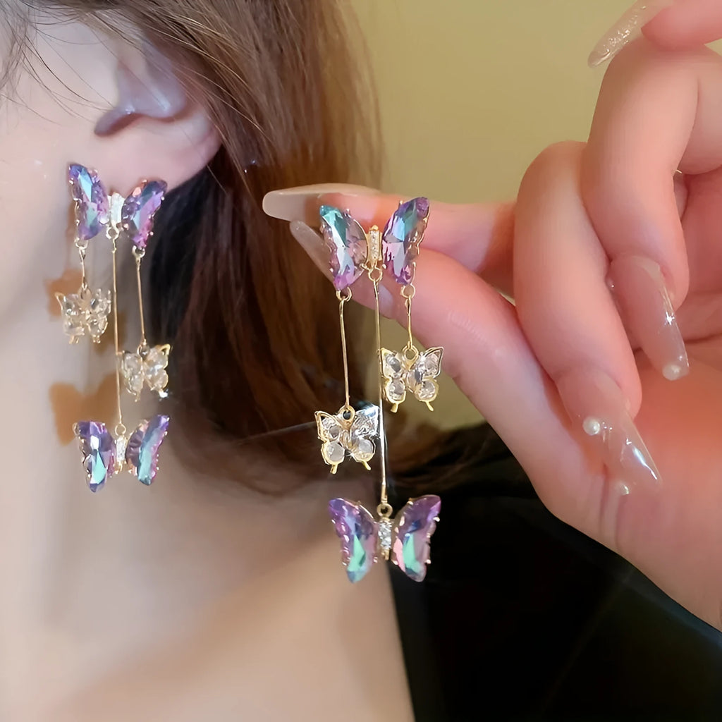 Close-up of women's silver needle blue purple butterfly tassel earrings with crystal flowers on alloy.
