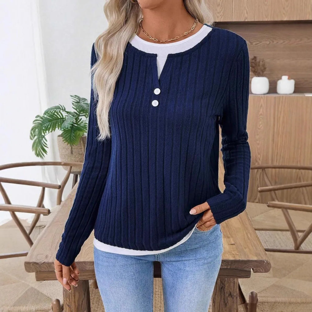 Women's black fake two-piece pullover sweater with button front and round neck on a hanger.