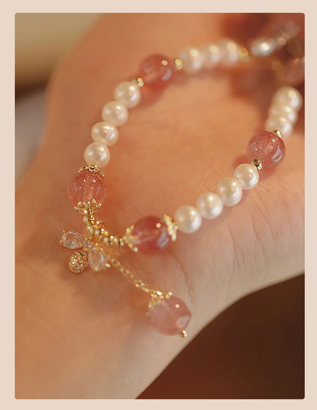 Close-up of a handmade crystal and strawberry quartz bracelet with a bow design, styled for women, INS aesthetic.