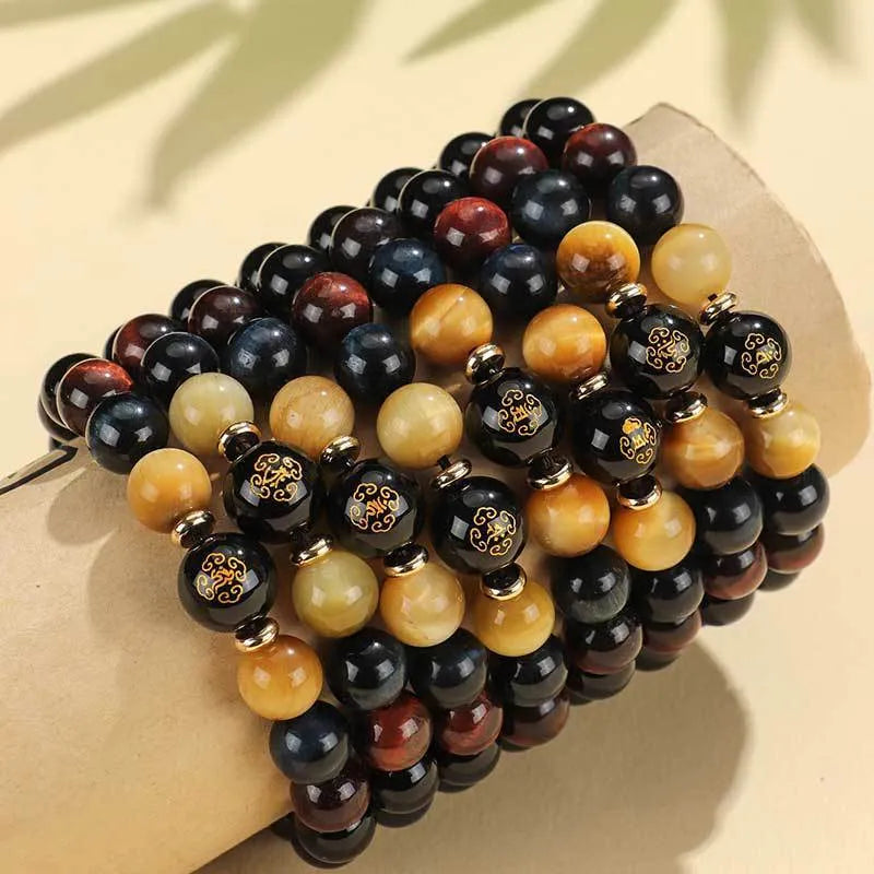 Black agate beaded bracelet with tiger eye stones in ethnic style on plain background