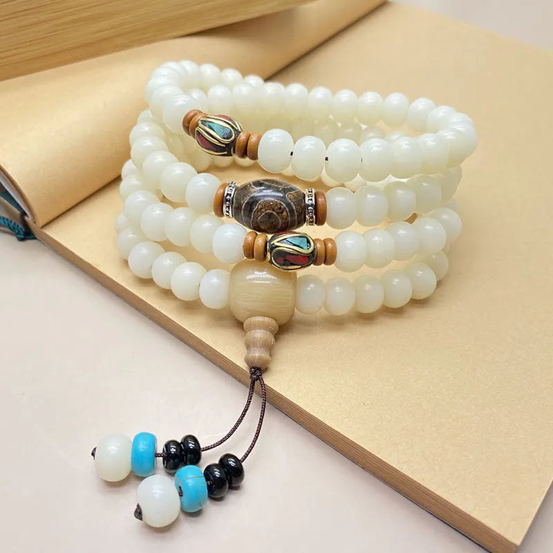 White Jade Bodhi 108 bead bracelet showing detail of spherical beads on a wrist.