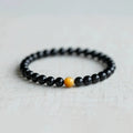 Natural black obsidian bracelet with geometric beads in 10mm size on neutral background