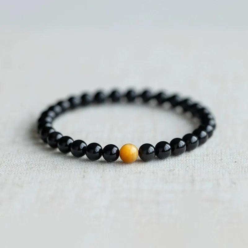 Natural black obsidian bracelet with geometric beads in 10mm size on neutral background