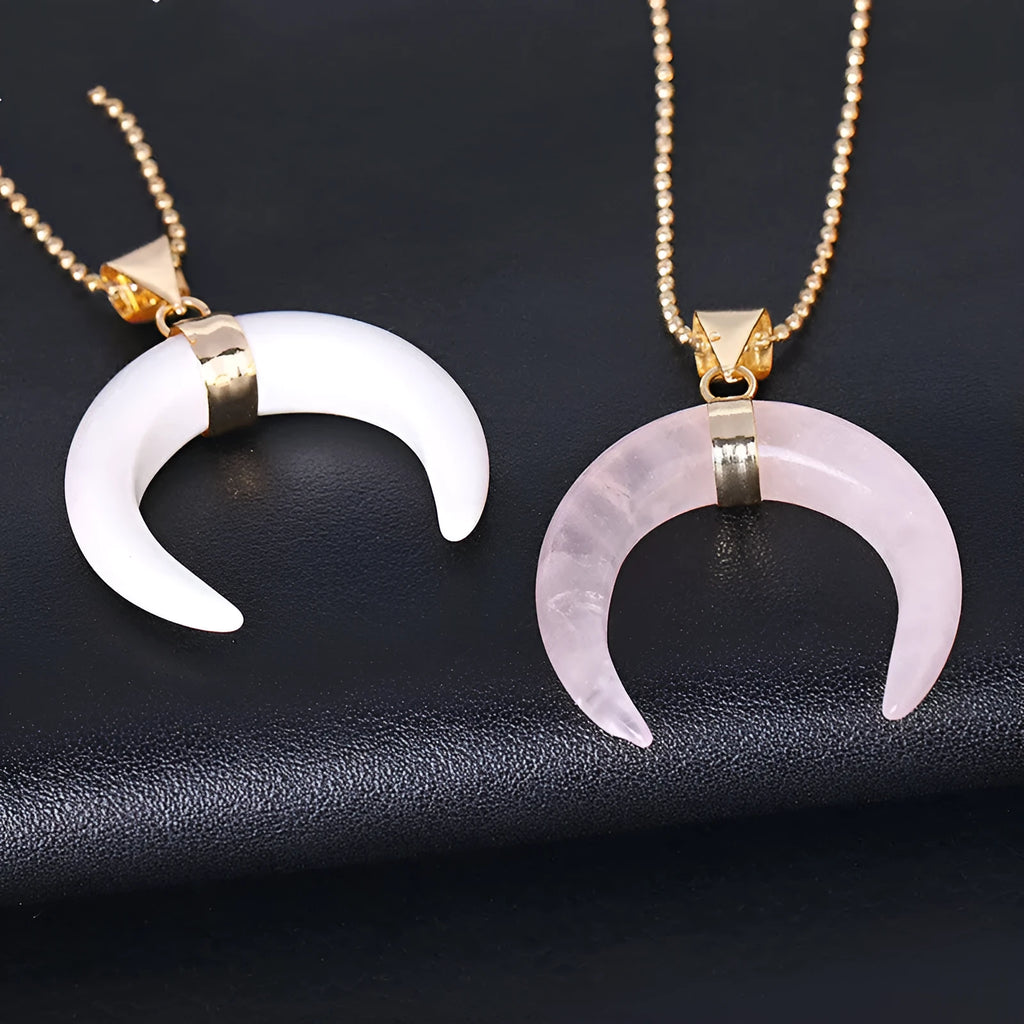 Close-up of a pink natural stone moon pendant necklace on a copper chain, showing textural detail.